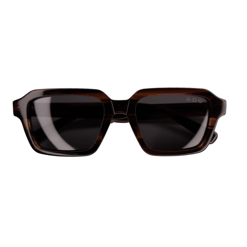 A pair of square sunglasses with a dark brown detailing acetate frame and dark lenses, shown against a plain white background. The brand name 'RDG' is subtly printed on the upper right corner of the lens.